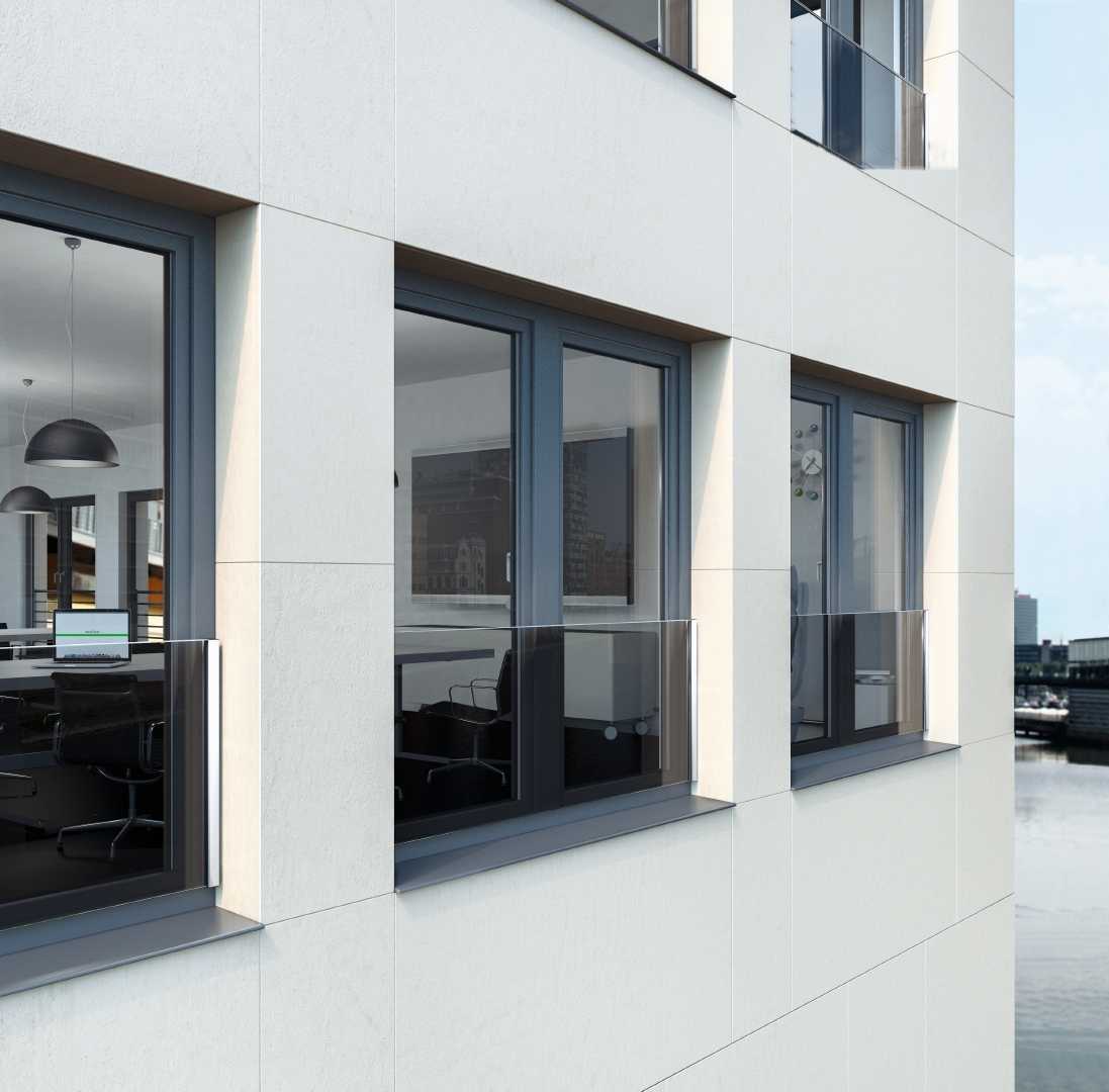 Dark grey window frames create a striking yet harmonious contrast with a light facade. The modern anthracite shade underscores the urban character of the building, appearing both elegant and technically clean.